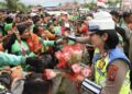 Hari Polwan ke-77, Komnas Perempuan Dorong Pengarusutamaan Gender di Kepolisian Polwan membagikan bunga kepada ojol di depan Polda Sumatera Utara. (Foto: Humas Polda Sumut)