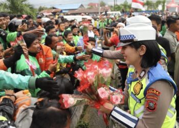Hari Polwan ke-77, Komnas Perempuan Dorong Pengarusutamaan Gender di Kepolisian Polwan membagikan bunga kepada ojol di depan Polda Sumatera Utara. (Foto: Humas Polda Sumut)