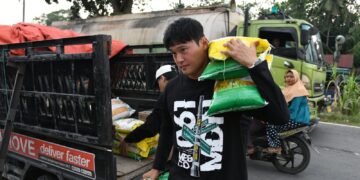 Bek PSMS Medan, Kim Jeung-Ho, saat membagikan bantuan kepada korban banjir di Langkat, Sumut. (Foto: Media Officer PSMS)