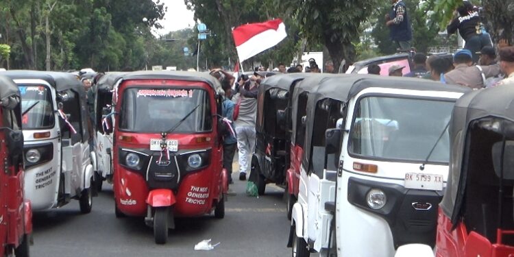 Pengemudi Bajaj Medan unjuk rasa di depan kantor Gubernur Sumatra Utara, Kamis (12/02/2026). Massa meminta 11 tuntutan ke manajemen Maxride. (Foto: narata/Ghiyatuddin)