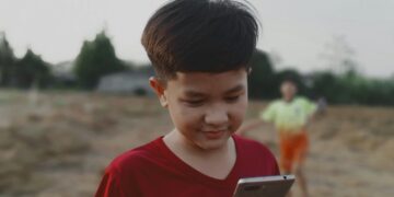 Keterangan Foto: Ilustrasi seorang anak bermain ponsel pintar. (Sumber: Yeon Li via Unsplash)