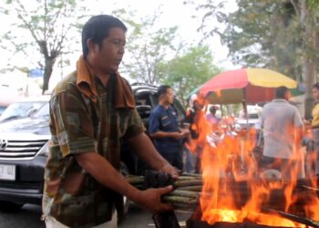 Pedagang membakar pucuk rotan pakat. (Foto: narata/Ghiyatuddin)