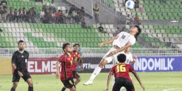 Keterangan Foto: Pemain timnas Indonesia U19, Raditya Yugie Rahardjo berebut bola di udara saat melawan Timor Leste U19 pada pertandingan lanjutan Piala AFF U19. (Sumber: Wan).
